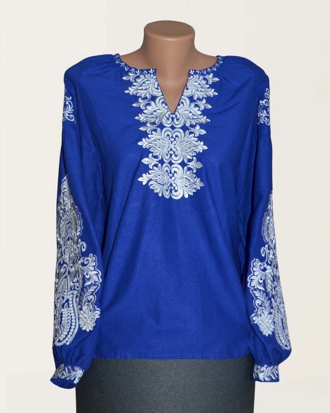 Elegant blue blouse featuring intricate white embroidery, perfect for casual or dressy occasions.