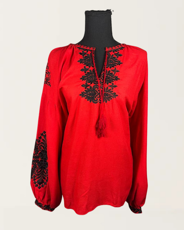 Red blouse with black embroidery detailing, featuring a relaxed fit and tassel neck design.