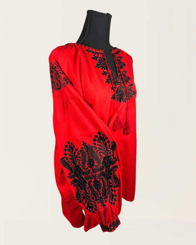 Red blouse with intricate black embroidery, featuring a relaxed fit and detailed tassel neckline.