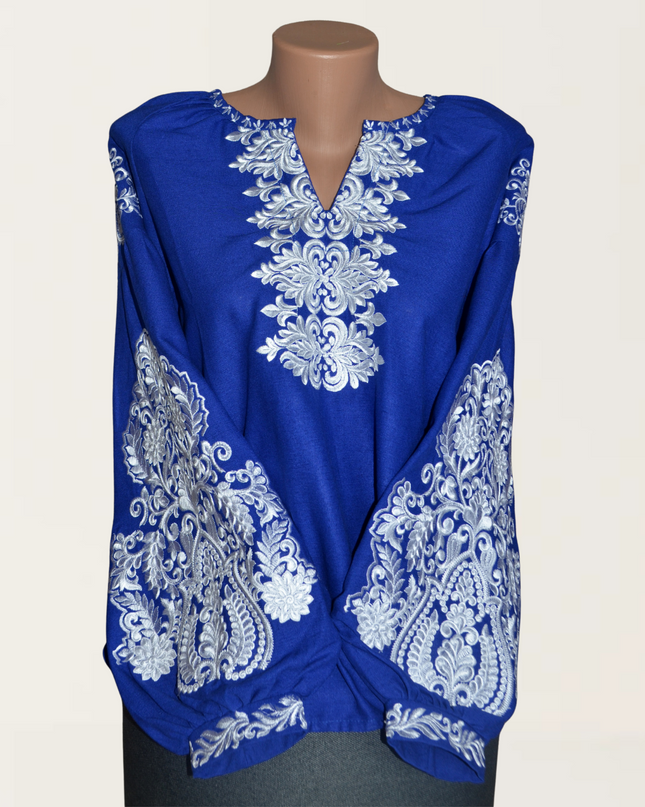 Elegant blue blouse featuring intricate white embroidery on sleeves and front, perfect for stylish summer wear.